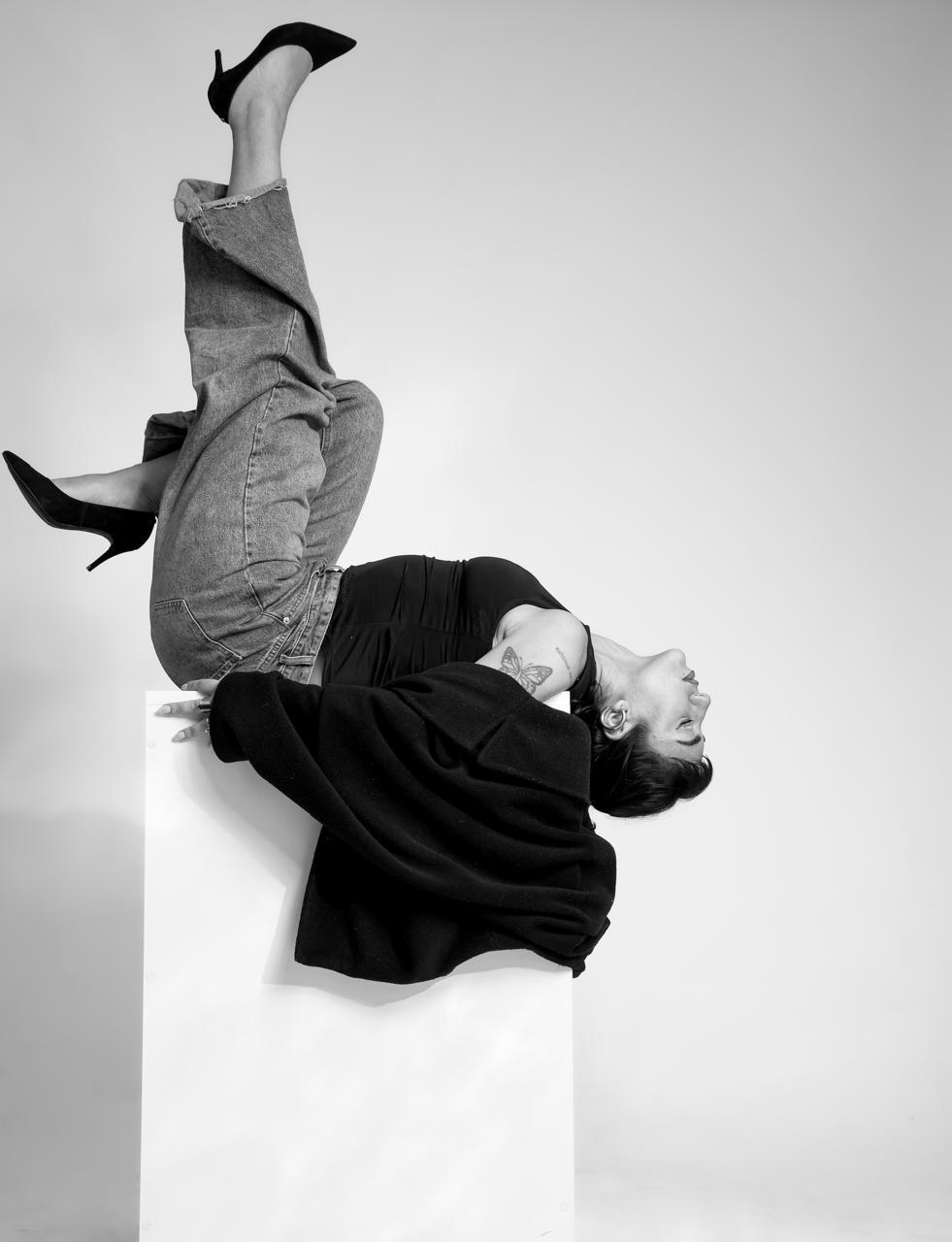 Agustina Noriega en una pose invertida sobre un pedestal, fotografía en blanco y negro